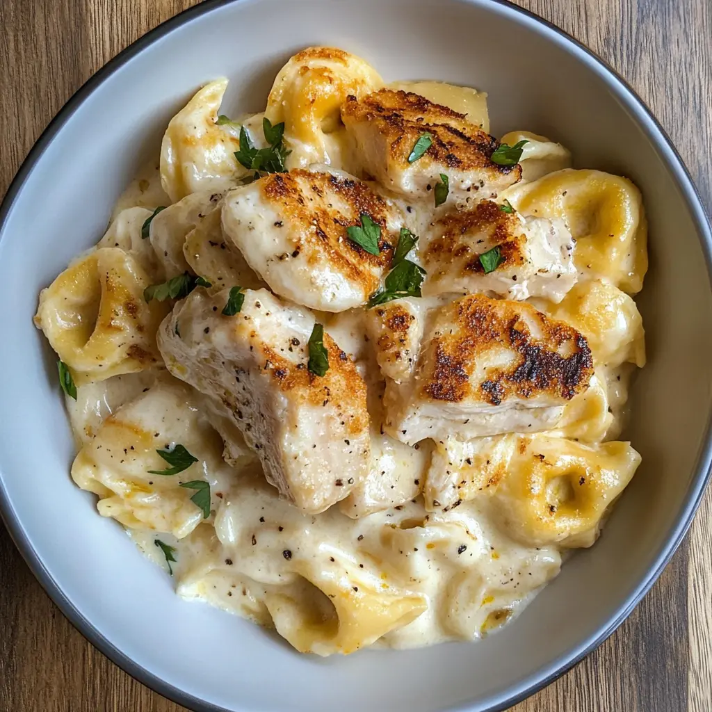 Creamy Asiago Tortelloni Alfredo with Grilled Chicken is a comforting dish that brings together rich flavors and hearty ingredients. The creamy sauce perfectly complements the tender tortelloni and juicy grilled chicken. Perfect for a family dinner or a special occasion! Save this recipe for an easy meal that everyone will love!